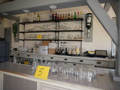 un bar avec de nombreux verres à vin posés sur le comptoir
