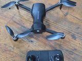 a remote control and a small black drone on a wooden table