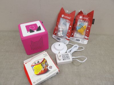 une radio rose et d'autres objets posés sur une table