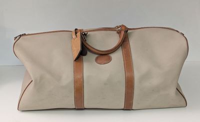 une photo d'un sac de voyage beige et marron posé sur une table