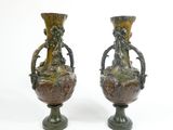 two vases that are sitting side by side on a white surface