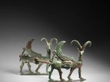 two bronze figurines of animals and a man on a sleigh