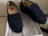 pair of men ' s shoes in a shoe box on a tiled floor