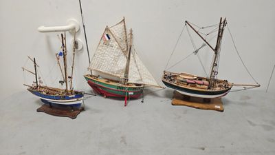three small model boats on display on a table