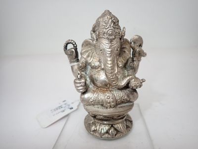 une statue en argent représentant un éléphant, posée sur une table