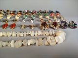 many different types of jewelry on a white surface