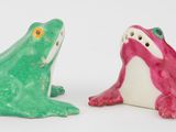 deux figurines représentant une grenouille et une autre grenouille, assises l'une à côté de l'autre