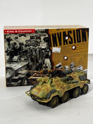 des véhicules militaires miniatures sont posés devant une boîte fermée