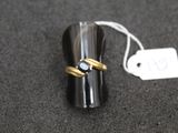 une bague sertie d'un diamant posée sur une table, à côté d'une étiquette de prix