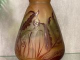 a vase with a picture of a woman on it on a glass shelf