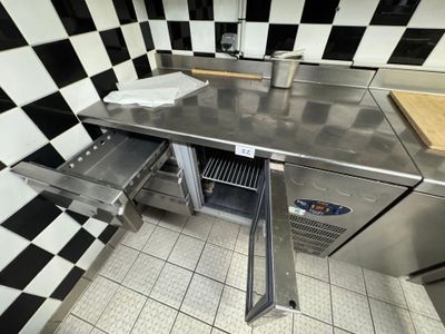 a stainless steel kitchen with a checkered wall behind it