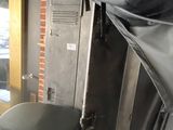 a toilet in the corner of a room with a black cover on it
