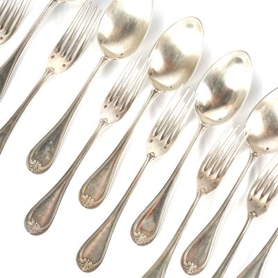 un grand nombre de cuillères et de fourchettes en argent sur une surface blanche