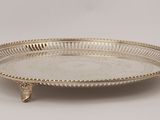 a silver plate on a stand on a white background