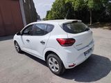 the rear end of a white car parked in a parking lot