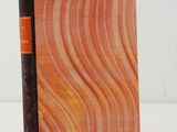 an orange and black book sitting on top of a white table