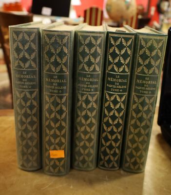 several books are stacked on a table in a library