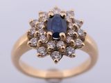 an oval sapphire and diamond cluster ring in yellow gold