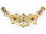 a close up of a gold necklace with pink stones on a white background