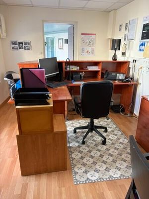 a desk with a chair and a laptop on it