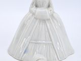 a figurine of a woman in a white dress and a dog