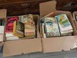 many boxes of books sitting on the floor next to a dresser