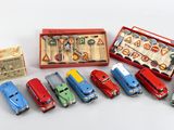 Il y a plusieurs petites voitures dans une boîte rouge et une boîte contenant des ciseaux