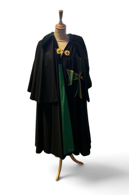 witch robe on a mannequin stand with a green ribbon