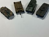 four small toy tanks sitting on a white surface