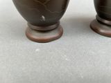 two vases that are sitting on a table