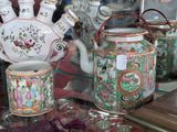 many vases and cups on display in a glass case