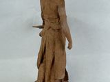 statue of a woman holding a tray of food on a white surface