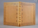 un vieux livre relié en cuir dont la couverture est ornée d'un motif décoratif
