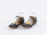 une paire de chaussures noires et dorées à talons transparents sur fond blanc