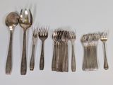 several forks and spoons are arranged in a row on a white surface
