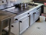 a large stainless steel kitchen with a stove and a sink