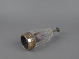 a small glass bottle with a metal stopper on a gray surface
