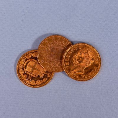 trois pièces d'or empilées les unes sur les autres sur un fond bleu