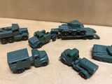 Plusieurs véhicules militaires miniatures sont alignés sur une table