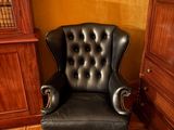 un fauteuil en cuir noir placé dans un coin d'une pièce