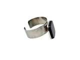 a close up of a silver ring with a black stone on it