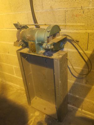 a machine that is sitting on the ground next to a brick wall
