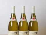 three bottles of wine sitting on top of a wooden table next to a bottle of wine