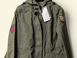 an army green jacket with patches and a tag on it