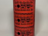 un vase rouge orné de nombreux motifs différents