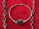 un gros plan d'un collier et d'un bracelet posés sur un tissu rouge
