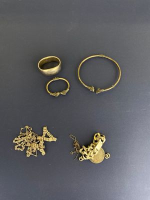 trois bagues en or et deux bagues en argent posées sur une table