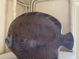 a brown fish sculpture on a white shelf in a room