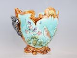a vase that has a bird on it on a stand
