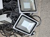 three flood lights sitting on the ground next to a pile of wires